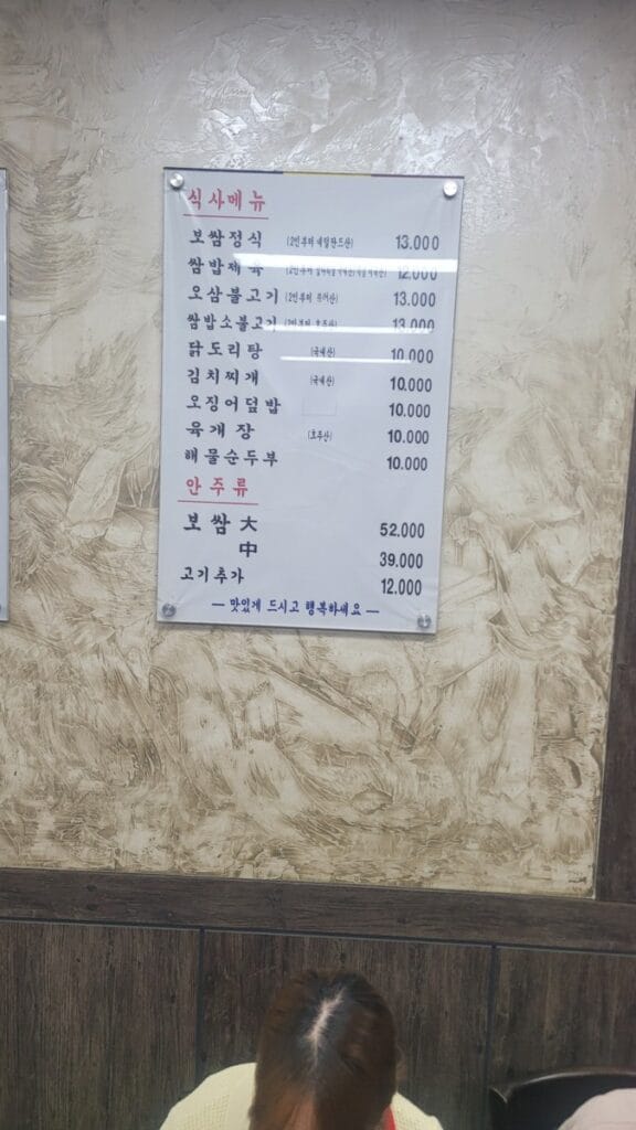Korean restaurant menu board showing prices and country-of-origin labels