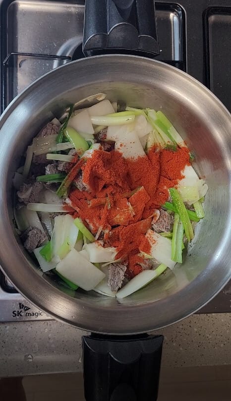 Frying gochugaru with scallion and beef until the oil turns red