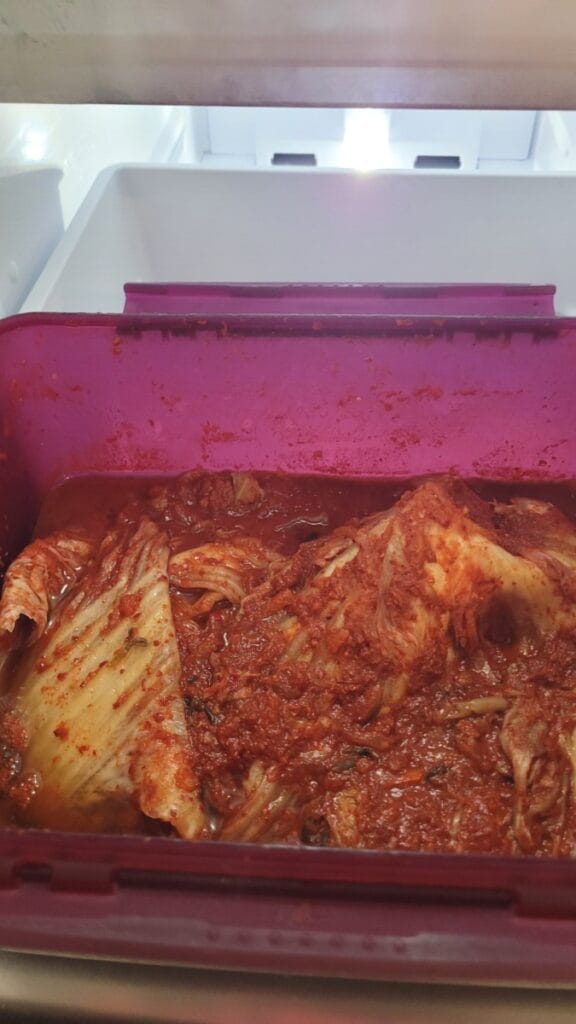 Whole-leaf kimchi in an open storage container in a Korean home