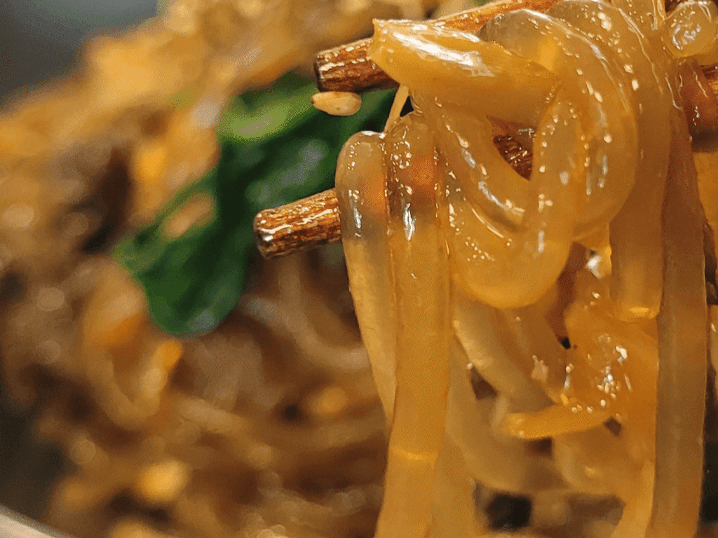 One-pan japchae with glass noodles, pork and vegetables on a plate