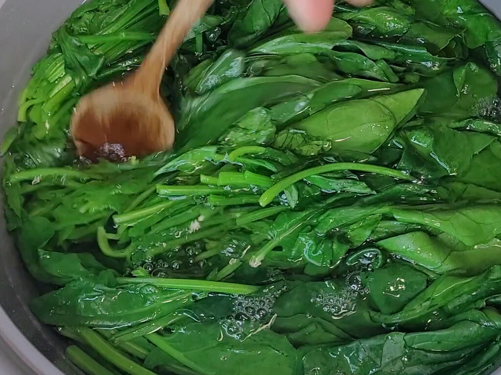 Spinach going into boiling salted water for a Korean side dish