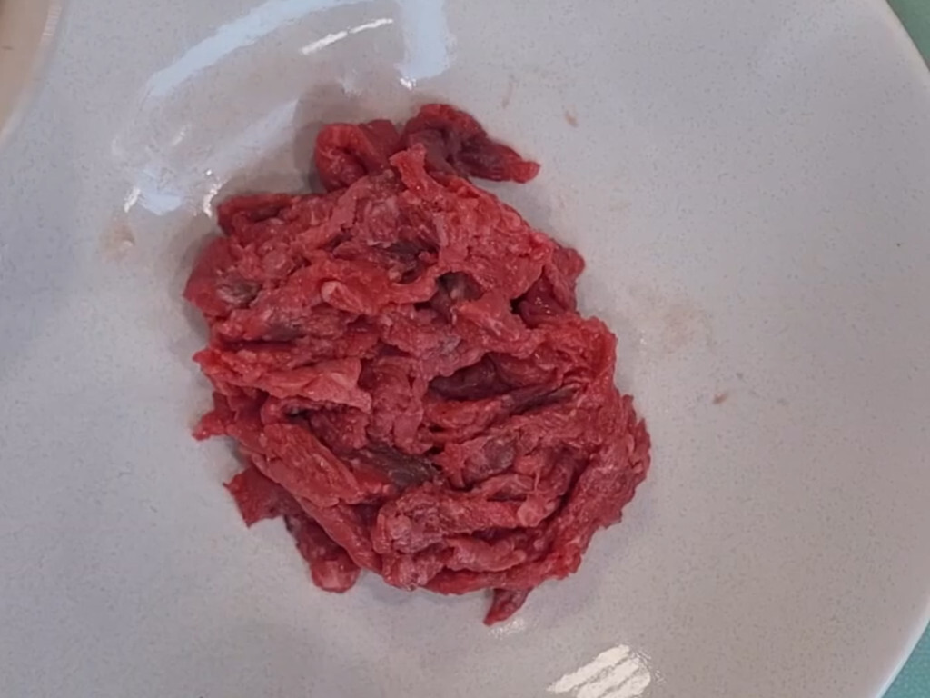 Thin strips of raw top round for yukhoe, not minced