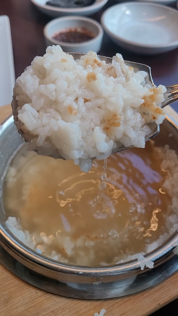 A spoonful of sungnyung with soft bits of scorched rice