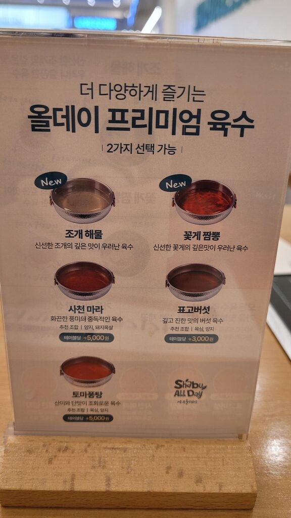 Seven broth choices at a Korean shabu-shabu buffet, with prices
