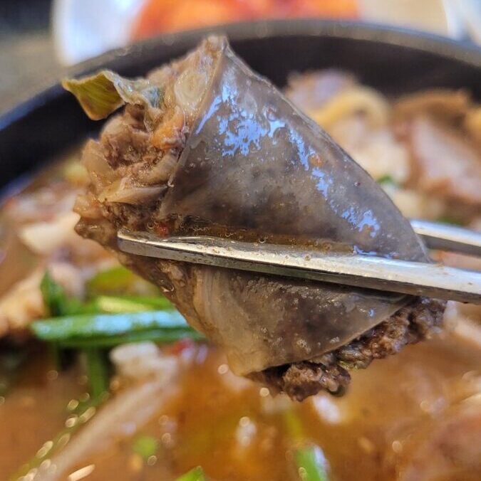 Baekam-style sundae cut open, showing a coarse pork and vegetable filling